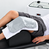 Richmar HydraHeat moist heat pack applied over a towel during knee heat therapy